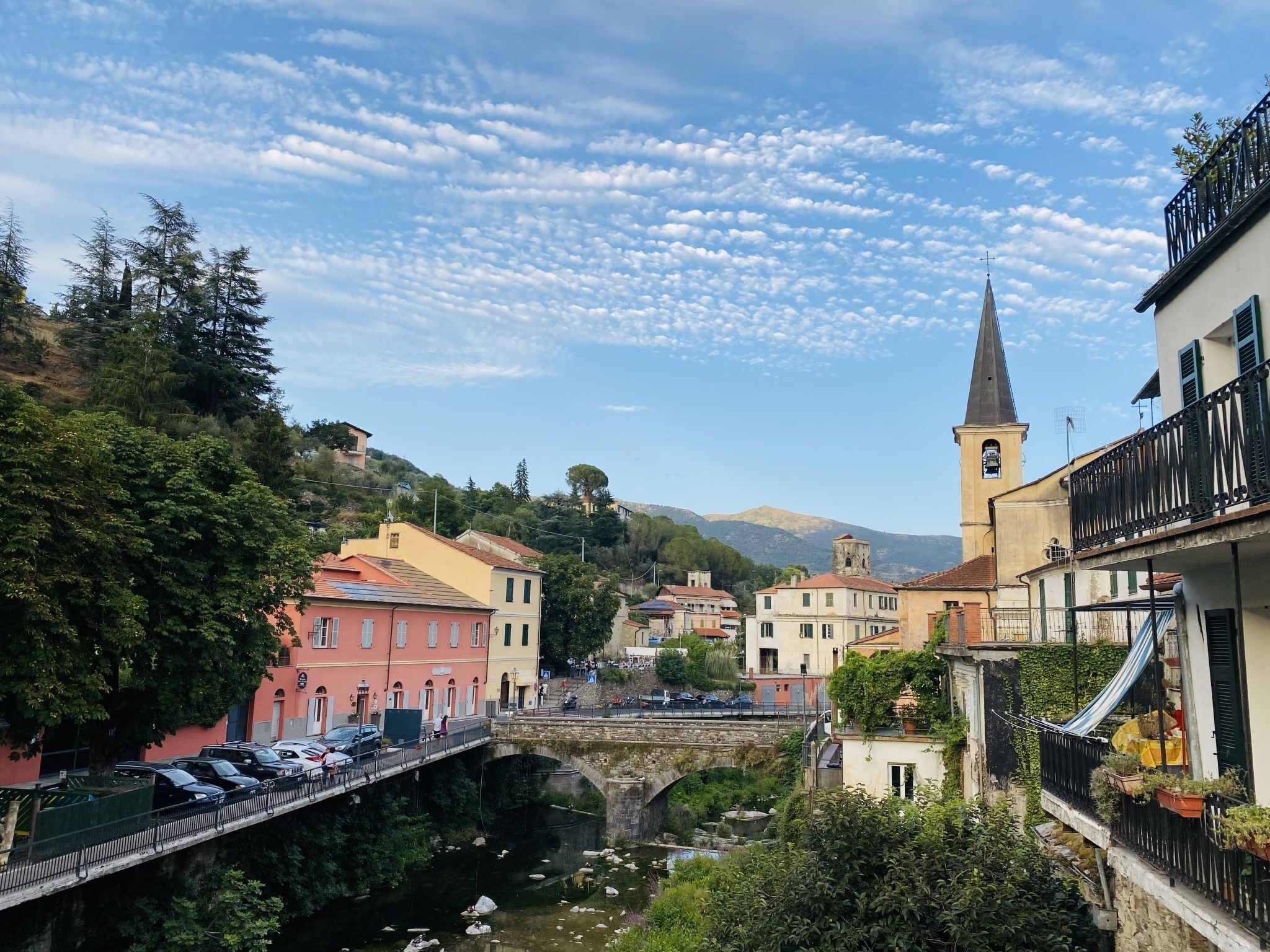 Une ville qui possède des bâtiments historiques, une église et un pont enjambant une rivière.