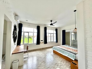 Relax in this serene bedroom with a large bed, ceiling fan, and window with curtains.