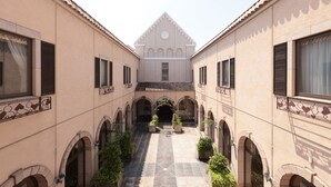 A courtyard with a central archway, surrounded by buildings with arched windows and a tiled roof. - HOTEL LiVEMAX Numata GRANDE (Numata)