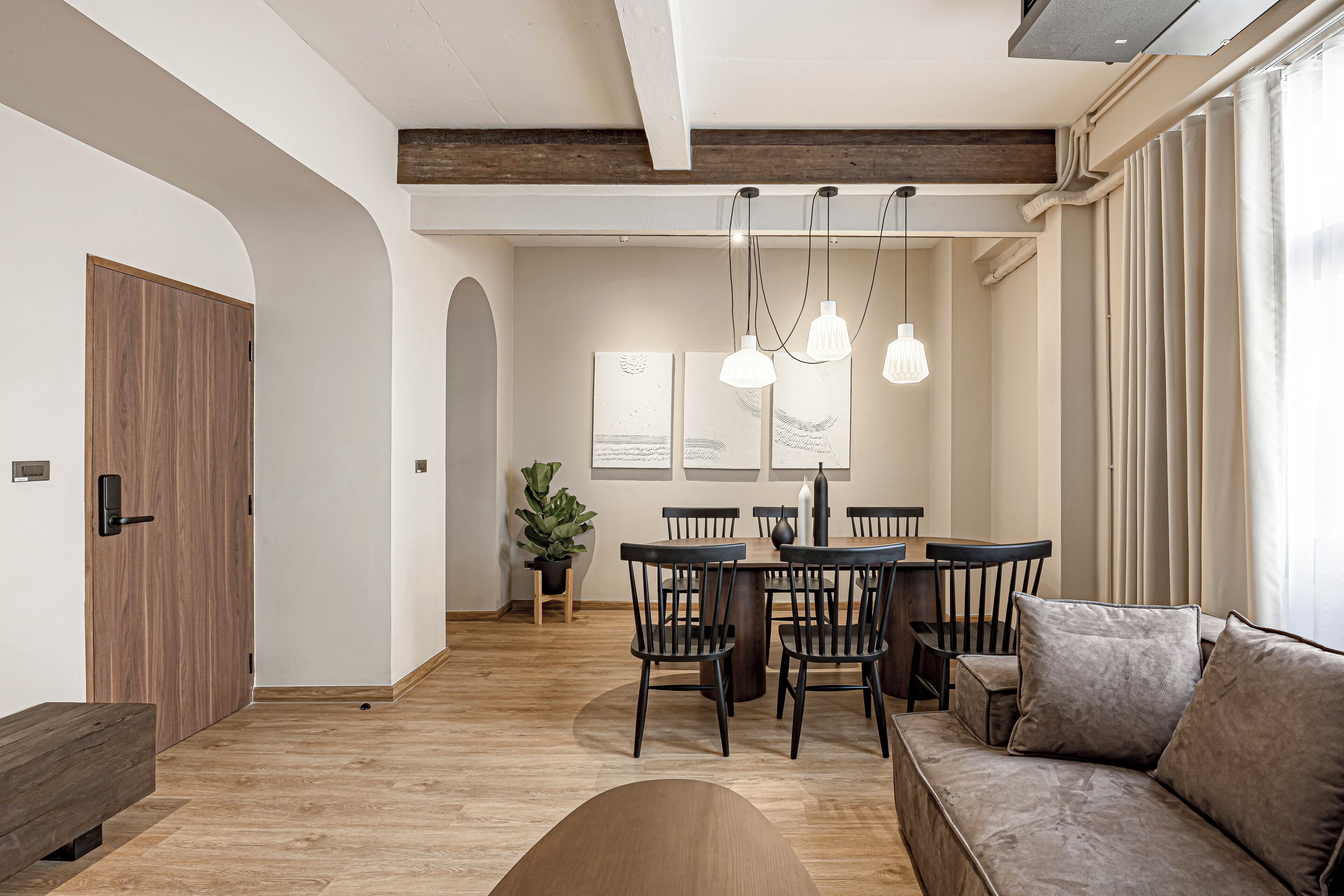 Un soggiorno moderno con una panca in legno, un divano e un'area pranzo con sedie e tavolo.