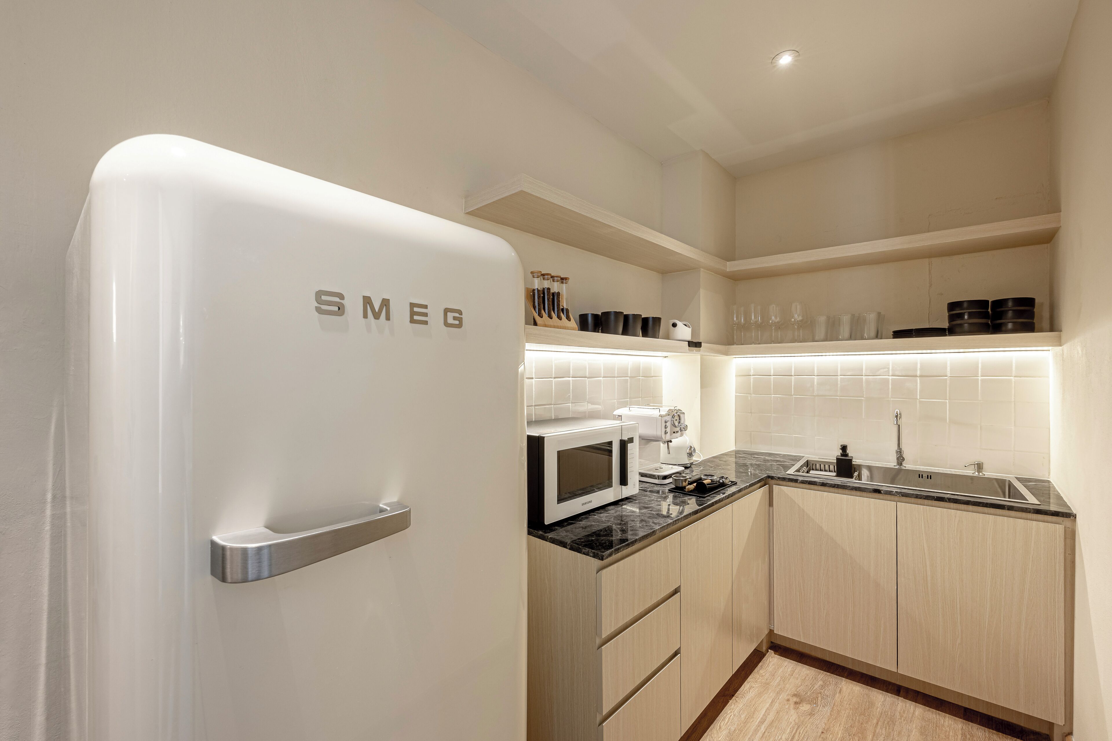 A modern kitchen with a white refrigerator, a microwave, and a sink.
