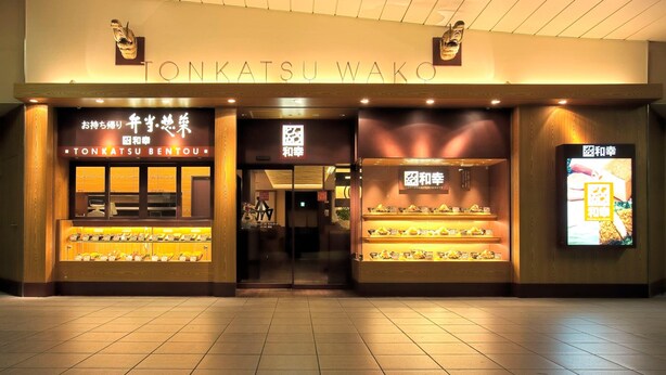 A storefront with the sign "TONKATSU WAKO" and displays of food items.
