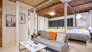 A modern hotel room with a sofa, a bed, a small table, and a projector.