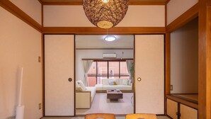 A traditional Japanese room with tatami flooring, a low wooden table, and a sofa. - Higashi Komagata Bldg. 2F3F (Tokyo)
