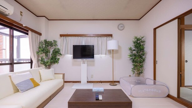 A living room with a sofa, a coffee table, a TV, and two lamps. - Higashi Komagata Bldg. 2F3F (Tokyo)