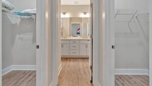 A hallway leading to a bathroom with a vanity, mirror, and towel rack. - Romana Hideaway-Main House, Downtown, New Listing! (Pensacola)