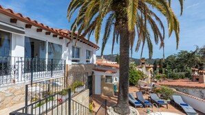 Una villa con piscina, palmeras y vistas a las colinas.