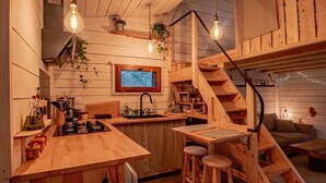 Une cuisine rustique avec des plans de travail en bois, une cuisinière intégrée et un coin bar en bois avec des tabourets.
