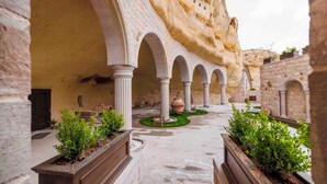 An interior courtyard with arches, columns, and planters. - Signature Cave Cappadocia, Trademark Collection by Wyndham (Ürgüp)