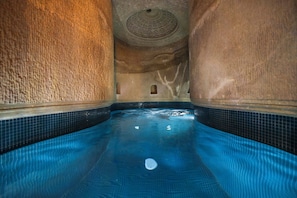 A pool with a tiled floor and walls, a ceiling with a circular design, and small windows. - Signature Cave Cappadocia, Trademark Collection by Wyndham (Ürgüp)