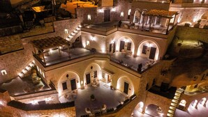 A multi-level courtyard with stone walls, outdoor seating areas, and staircases. - Signature Cave Cappadocia, Trademark Collection by Wyndham (Ürgüp)