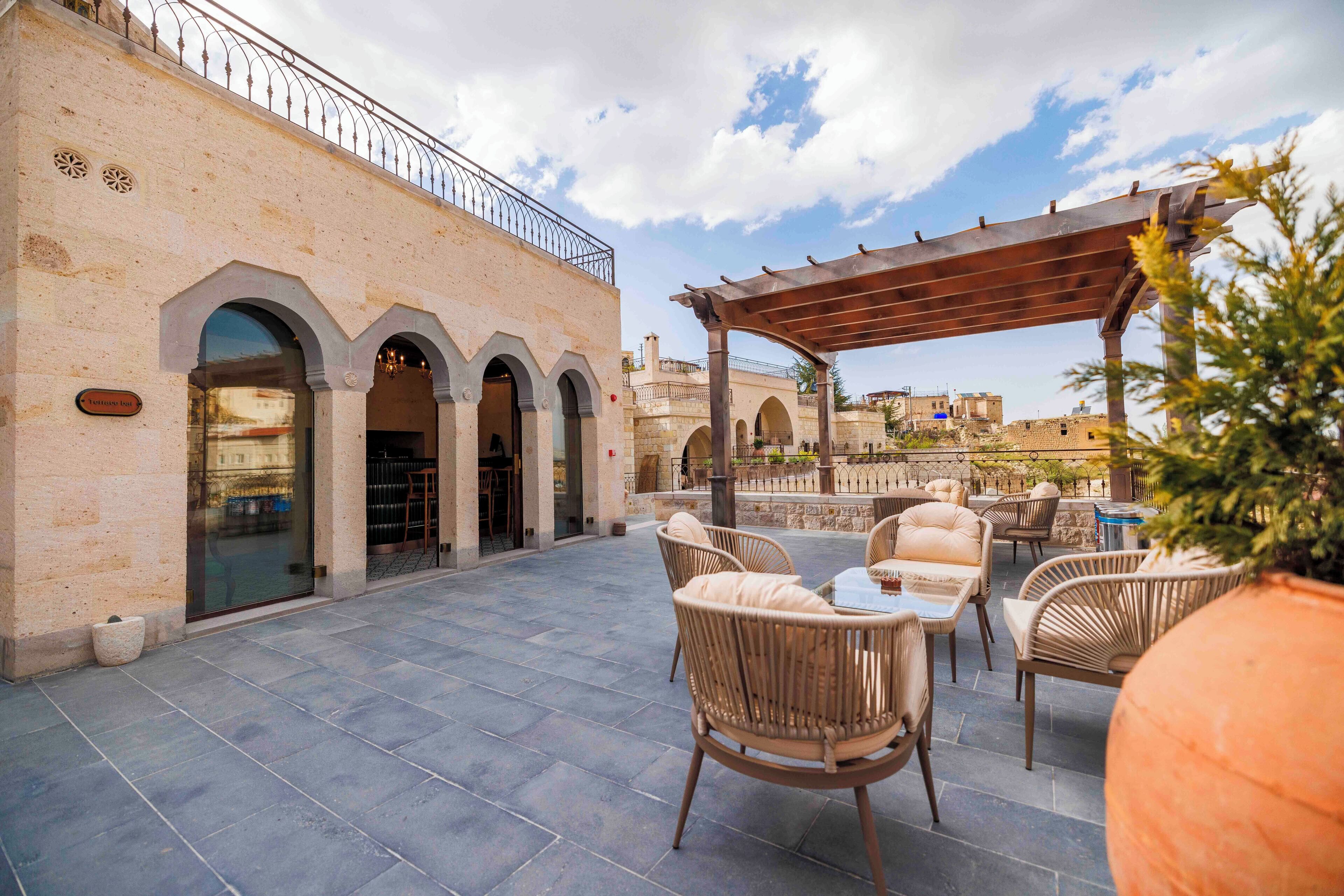 An outdoor patio area with wicker furniture and a pergola.