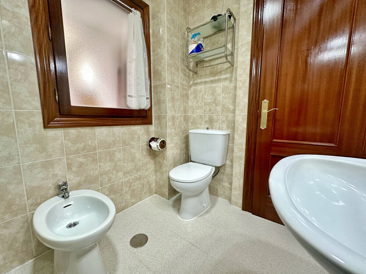 A bathroom with a toilet, bidet, and sink.