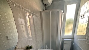 A modern bathroom with a sink, bidet, toilet, and a shower area.