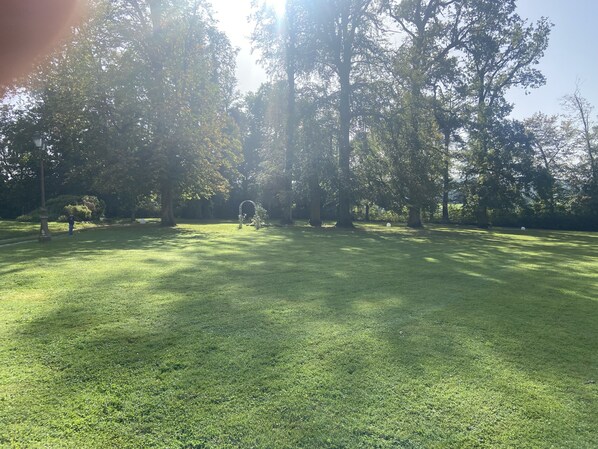 A grassy park area with trees and a lamp post. - Mobil-home, Niché au Cœur de la Campagne (Rosoy-en-Multien)