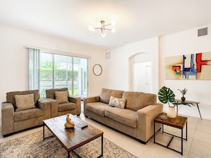 A modern living room with two sofas, a coffee table, and a large window.