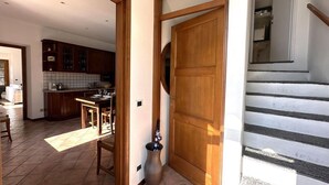 Ein Flur mit einer Holztür, die in einen Küchenbereich führt.