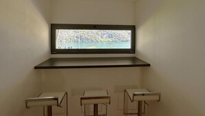 A bathroom with a window overlooking a body of water and a cityscape. - Riflessi sul Lago Apt Laglio - Tramonto (Laglio)