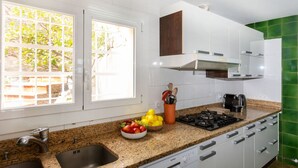 Una cocina moderna con encimeras de granito, armarios blancos y lavavajillas integrado.