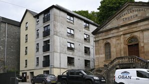 A multi-story building with a stone facade and a sign for '1880 Congregational Church'.