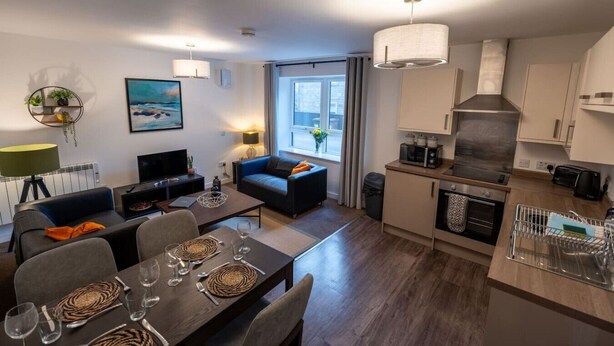 A modern apartment with a dining area, living room, and kitchen.