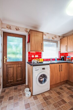 Kjøleskap, mikrobølgeovn, ovn og høy barnestol