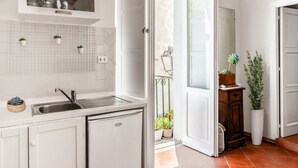 A kitchen with a sink, a small refrigerator, and a window with a view of the outside. - Casa Livia Sperlongaresort (Sperlonga)