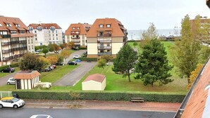 Et boligområde med lejlighedsbygninger, en vej og parkerede biler.