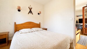 Un dormitorio con una cama de madera, mesitas de noche y lámparas de pared.