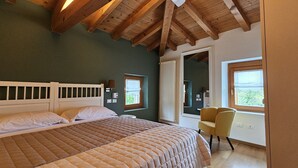 Un dormitorio con una cama grande, una silla, un ventanal y vistas al exterior.