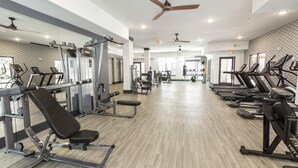A gym with various exercise equipment, including treadmills, weight machines, and free weights. - Landing | Modern 2BD, Clubhouse, Yoga Studio (Jacksonville)