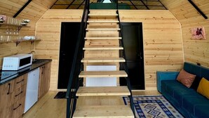 A wooden interior with a staircase leading to a loft bedroom. - Kazbegi Inn Cottages  (Kazbegi)