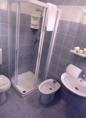 A bathroom with a glass-enclosed shower, a toilet, a bidet, and a sink. - Spend your holiday by the pool-Beahost (Bibione)