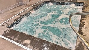 A hot tub with a tiled edge and a metal railing. - BaseLoj - Pool, Firepit, Bike to Mountain! (Killington)