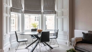 A dining area with a round table, four chairs, and a bowl on the table.