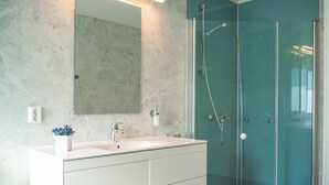A modern bathroom with a white vanity, a large mirror, and a glass-enclosed shower. - KROKSTRAND FJELLPARK (Mo-I-Rana)