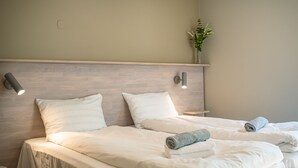 A hotel room with two beds, white linens, and a wooden headboard. - KROKSTRAND FJELLPARK (Mo-I-Rana)