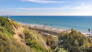 Une vue sur la côte, avec une plage, des palmiers et un phare.