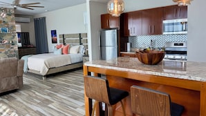 A modern kitchen with wooden cabinets, a stainless steel refrigerator, and a marble countertop. - Sunset Hideaway Suite - Oceanview/central to Cruz Bay  (St John)