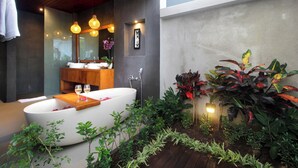 A modern bathroom with a freestanding bathtub, wooden vanity, and a large mirror. - The Sidemen Villas (Sidemen)