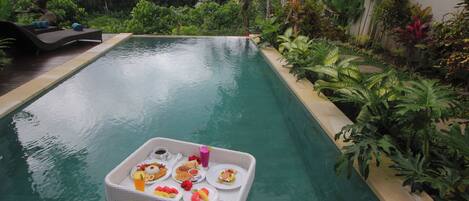 A poolside dining setup with a tray of food and drinks.