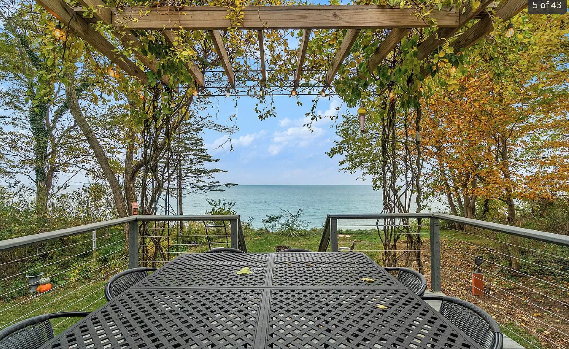 Uma área de estar coberta ao ar livre, com vista para o mar.