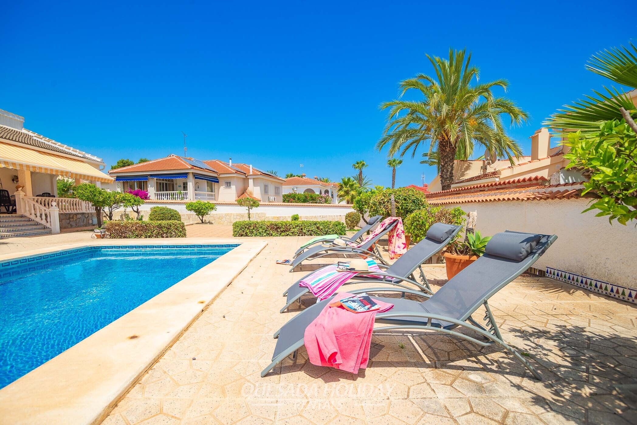 Un espace aménagé au bord de la piscine, avec des chaises longues et une piscine.