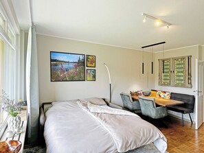 Quarto com cama, escrivaninha e cadeira. Há duas quadros na parede.