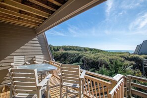 Enjoy outdoor dining or relaxation on this deck with a lush landscape view.