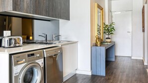 Una cucina compatta con elettrodomestici Bosch, un lavello e una lavastoviglie.