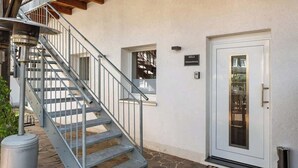 Una escalera conduce a una puerta con un cartel que dice "MOLA" y un felpudo de bienvenida.