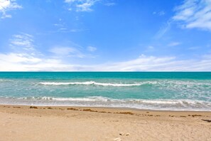 Een strand met helder turquoise water en een zandstrand.