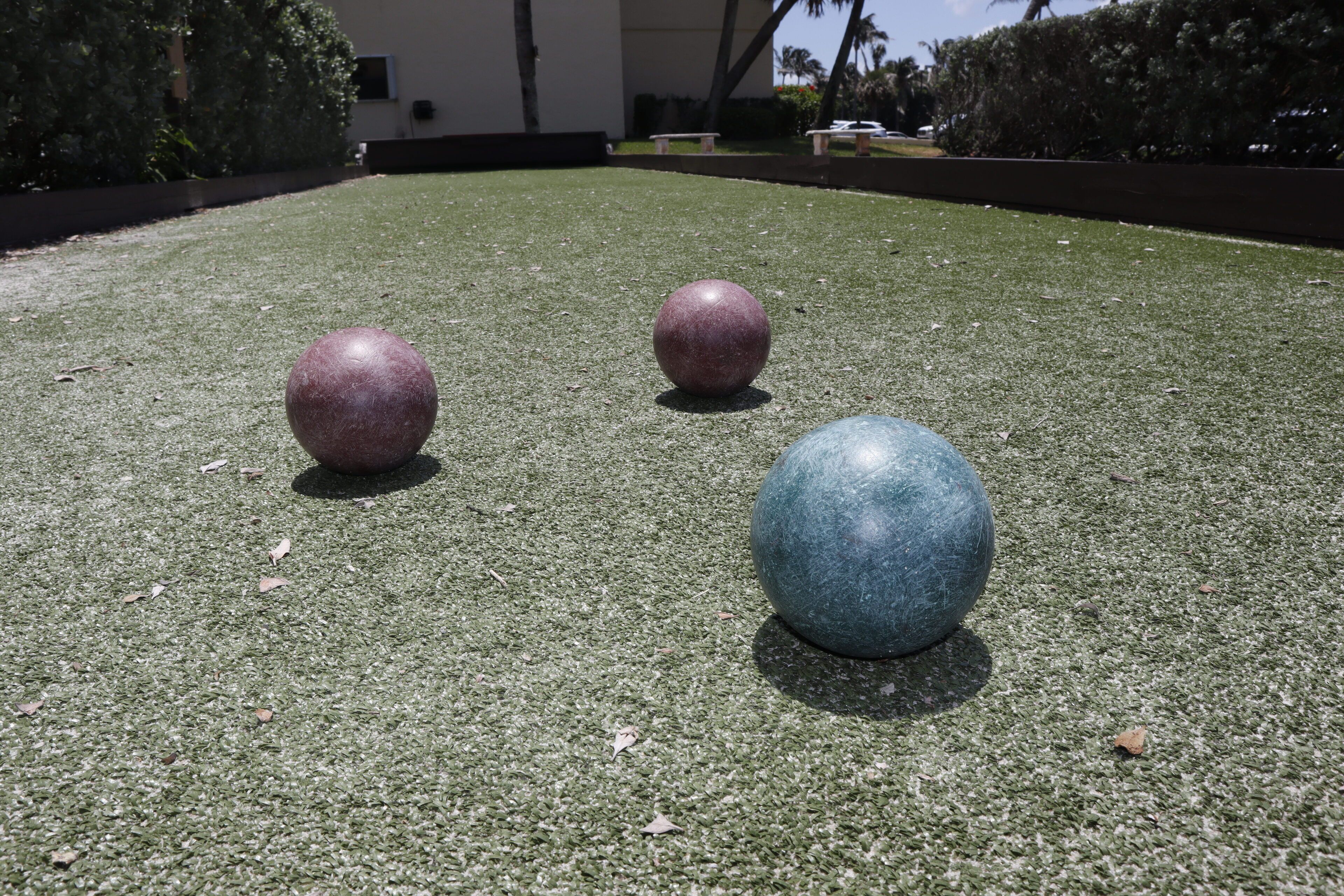 Tres pelotas sobre una superficie verde.