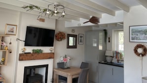 Ein modernes Wohnzimmer mit Kamin, Essbereich und Küche.